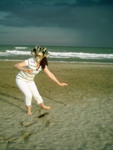 Dancing on Lido beach, wearing a Venice theater mask. 